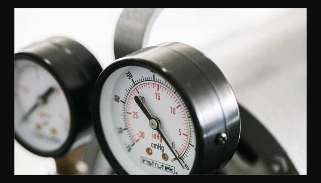 Close-up of refrigerant pressure gauges used to check for leaks in a cold room refrigeration system
