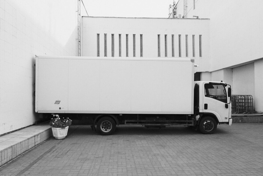 White refrigerated delivery truck parked beside a building