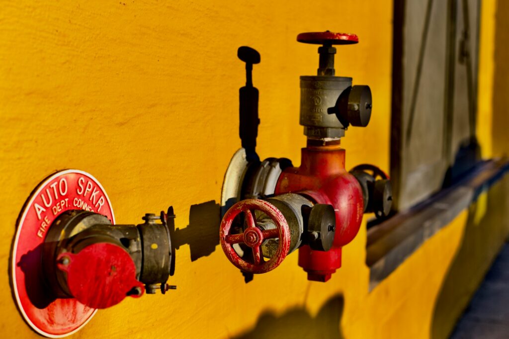Red fire protection valve on sprinkler pipework