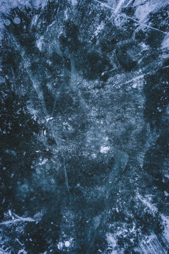 Close-up of cracked ice surface illustrating frost buildup on a cold room evaporator